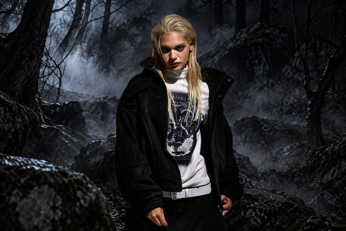 Model wearing BSRABBIT 26/27 FW outerwear in a dark, misty forest