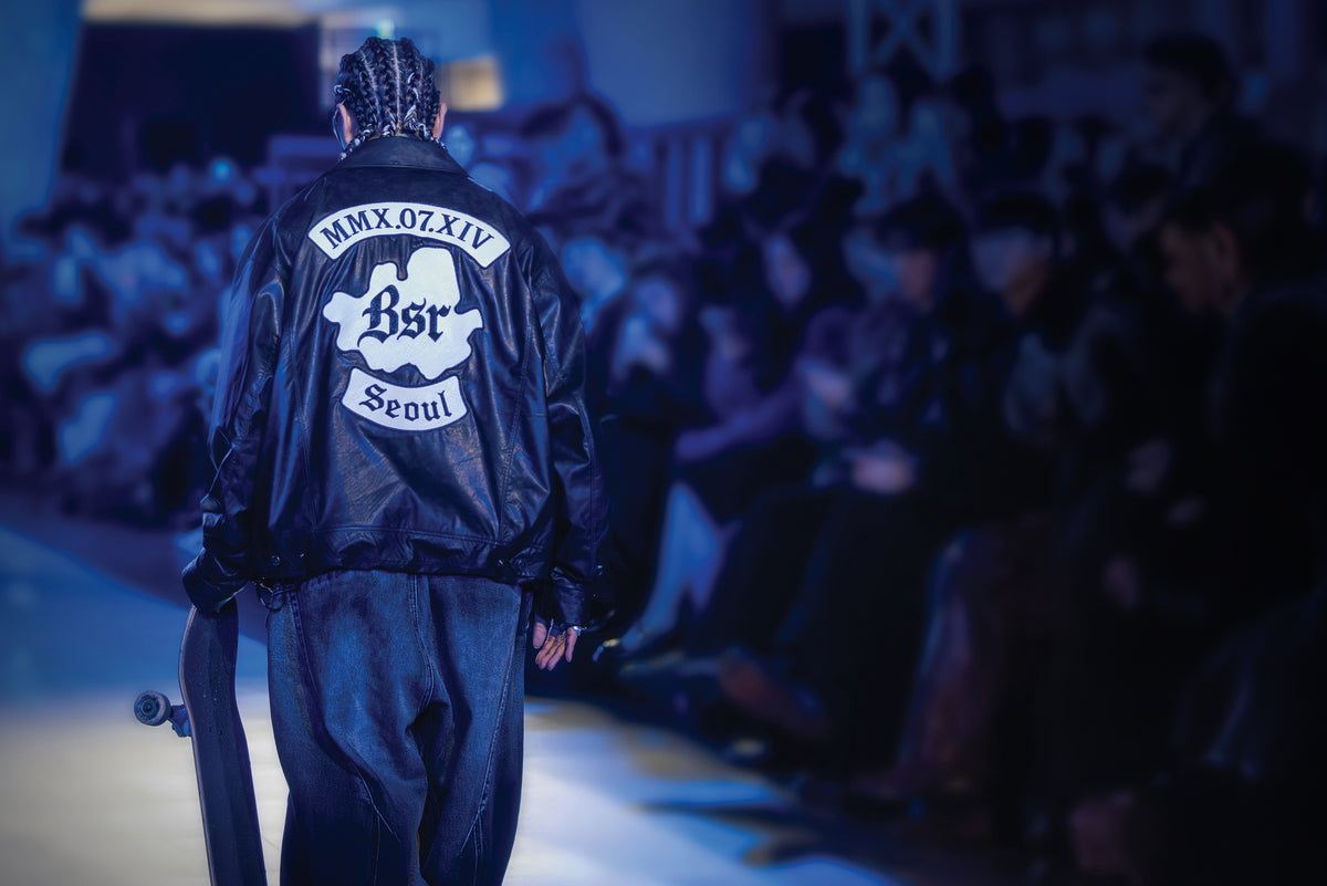 Skateboarder wearing a BSRABBIT Seoul leather jacket under blue runway lights